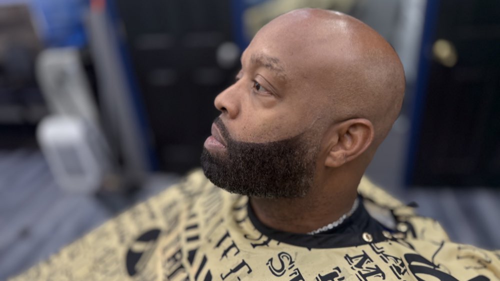 Client in the chair with a completed fade and beard trim.