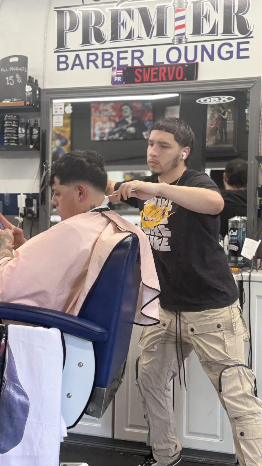 Barber performing clipper work on a client inside Parma's Premier Barber Lounge.